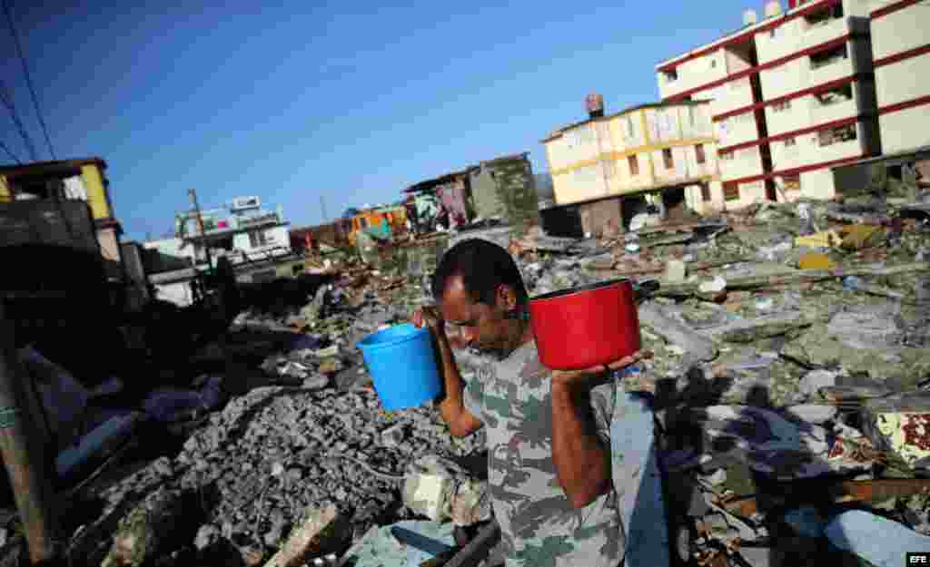 Cubanos recolectan agua hoy, viernes 7 de octubre de 2016, tras el paso hace tres días del huracán Matthew en Baracoa (Cuba).EFE/Alejandro Ernesto