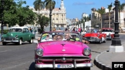 Turistas pasean por el Prado habanero en un "almendrón" americano de los años 50.