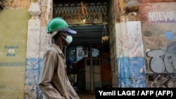 Un cubano camina por La Habana con una máscara para protegerse del COVID-19. (Yamil LAGE / AFP)