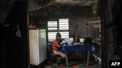 Una señora escoge arroz en su casa en El Caney, Santiago de Cuba el 21 de junio de 2017.