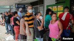 La gente espera en fila para comprar comida en un supermercado de Managua después de que el gobierno reportara el primer caso de COVID-19 en marzo de 2020.