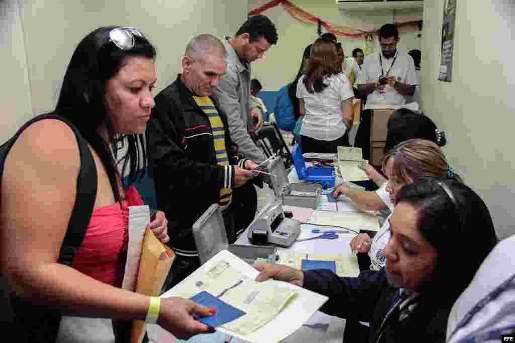 Imagen cedida por el Ministerio de Relaciones Exteriores que muestra a los cubanos en tránsito hacia EE.UU. mostrando su documentanción hoy miércoles 13 de enero de 2015 en el Aeropuerto Internacional de El Salvador Monseñor Oscar Arnulfo Romero y Galdámez