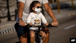 Un padre lleva a su hija en bicicleta por una calle de La Habana. (AP/Ramón Espinosa)