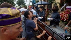 Cubanos orando el 16 de diciembre de 2023, en el Día de San Lázaro, en El Rincón. (AP/Ismael Francisco).