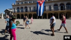 Una mujer vende gorras verde olivo de estilo militar a los turistas en la Plaza de Armas de La Habana Vieja.