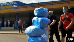 Cubanoamericanos arriban al aeropuerto José Martí, de La Habana, cargados de equipaje, tras la reapertura de la terminal aérea. (Yamil LAGE / AFP)