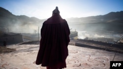 Monje budista tibetano contempla la salida del sol durante celebración de Año Nuevo Tibetano. (Johannes Eisele/AFP).