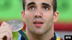 Danell Leyva muestra la medalla de plata que ganó hoy en el evento de barras paralelas en Río 2016