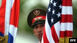 Soldados cubanos sostienen banderas de Cuba y Estados Unidos durante la visita de Obama a Cuba. (Foto: Archivo)