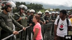 Una mujer grita consignas a integrantes de la Guardia Nacional Bolivariana que bloquean el paso al Tribunal Supremo de Justicia.