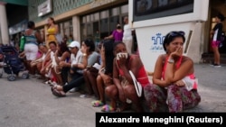 Un grupo de personas espera en una cola para comprar alimentos en una tienda de La Habana Vieja, en la capital cubana, el 3 de octubre de 2022. (REUTERS/Alexandre Meneghini)