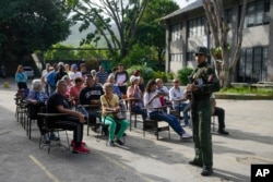 Votantes esperan su turno para ingresar a los colegios electorales durante las elecciones presidenciales en Caracas, Venezuela, el domingo 28 de julio de 2024. (Foto AP/Fernando Vergara)