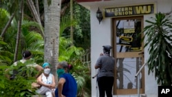 Personas esperan afuera de una oficina de la Western Union en La Habana.