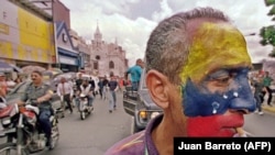 Un trabajador en Venezuela en medio de una protesta (Juan Barreto / AFP).