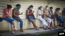 Nasobucos y distancia social en una cola para conseguir alimentos en Cuba (Adalberto Roque / AFP).