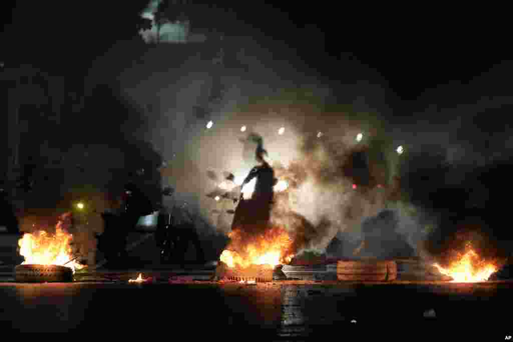 La sombra de un motociclista atraviesa una barricada en la avenida Bolívar en Caracas, Venezuela, el lunes 29 de julio de 2024, el día después de las elecciones presidenciales. (Foto AP/Matías Delacroix)