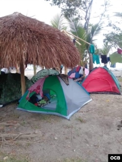 Las carpas de colores en la playa no son de vacacionistas, sino de migrantes desperados por continuar su ruta.