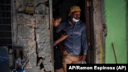  Emilio Román, padre de tres jóvenes prisioneros políticos por manifestarse el 11J, junto a su nuera María Carla Milan Ramos en su casa en el barrio La Güinera. ,