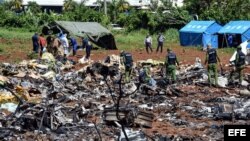 Personal cubano trabaja entre los escombros del avión accidentado en La Habana. 