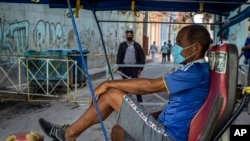 Un bicitaxista espera clientes afuera de una vivienda, en La Habana, donde la policía controla el acceso a un vecindario. (AP/Ramon Espinosa)