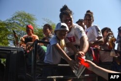 Migrantes hondureños reciben comida en Acacoyagua, Chiapas, México.