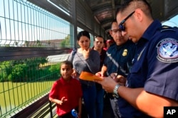 Funcionarios de Frontera procesan a una familia cubana en el Puente Internacional de Nuevo Laredo, Texas el 10 de julio de 2019. Foto AP /Salvador Gonzalez