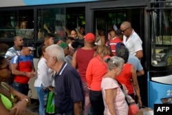 Una guagua atestada de pasajeros en La Habana. AFP/ Yamil Lage