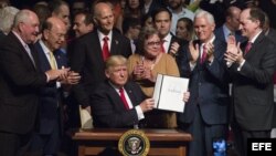 El presidente estadounidense, Donald J. Trump, firma el memorando presidencial sobre la política con Cuba tras finalizar su discurso en el teatro Manuel Artime de la Pequeña Habana, en Miami.