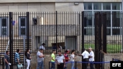 Varias personas hacen fila frente a la embajada de Estados Unidos en La Habana.