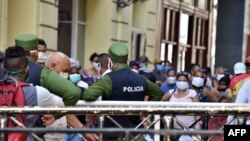 Policías controlando la población en una cola para conseguir alimentos, el 12 de abril del 2020. (AFP).