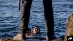 Un guardia civil español espera a que lleguen varios migrantes a la orilla del enclave español de Ceuta, cerca de la frontera entre Marruecos y España, el miércoles 19 de mayo de 2021. (AP Foto/Bernat Armangue)