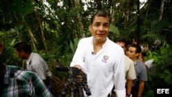 Foto de archivo del expresidente Rafael Correa con la mano manchada de crudo de un reservorio antiguo de desechos petroleros en la Amazonía. 