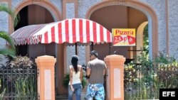 Una pareja de jóvenes entra en la pizzería de un trabajador "cuentapropista" en La Habana. EFE