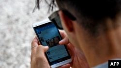 Archivo. Un joven se conecta a Twitter desde su telefono en La Habana. (YAMIL LAGE / AFP)