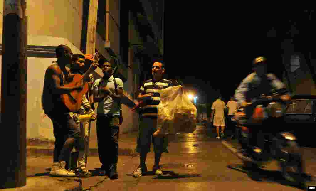 Un grupo de jovenes departe este martes en una calle del centro histórico de Santiago de Cuba (Cuba). 