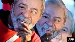 Miembros del Movimiento de los Sin Tierra portan máscaras con el rostro del expresidente Luiz Inácio Lula da Silva.