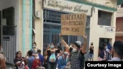 Joven con cartel protesta en el bulevar de San Rafael, La Habana