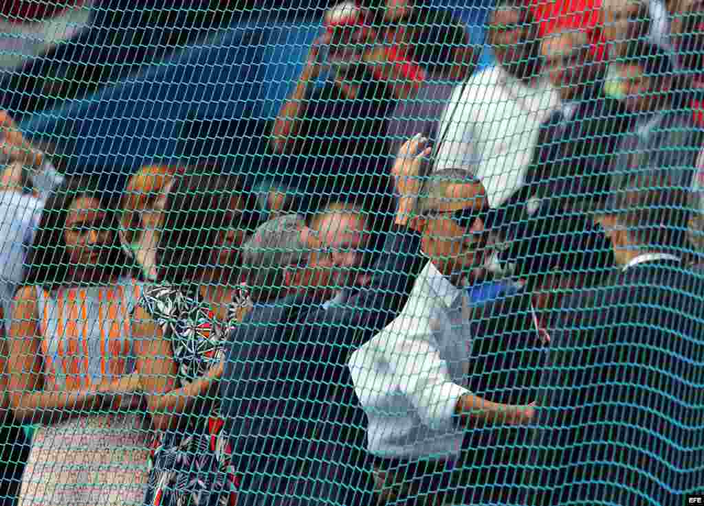 Barack Obama (2d), su esposa, Michelle (2i), su hija Sahsa (i) y el mandatario cubano, Raúl Castro (c), llegan al juego de béisbol entre el equipo de Cuba y los Rays de Tampa Bay.