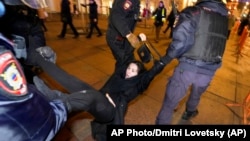 La policía rusa detiene a una manifestante en una protesta contra la invasión a Ucrania en St. Petersburg.