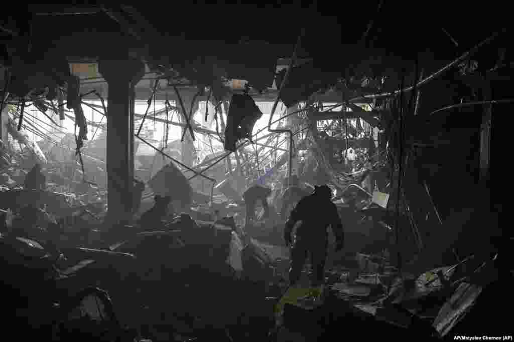 Bomberos y militares ucranianos en busca de sobrevivientes entre los escombros de un centro comercial después de un bombardeo ruso en la capital ucraniana de Kyiv. AP/Mstyslav Chernov