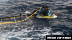 Elián López, con su tabla de surf, rescatado por la Guardia Costera de EEUU.