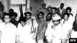 Foto fue tomada en el vivac de Santiago de Cuba, el 1 de agosto de 1953, horas después que los rebeldes se entregaron en la finca de Manuel "Lelín" Leizán Montero. De izquierda de a derecha, Fidel Castro, Eduardo Montano Benítez, soldado Rafael Morales Gros (con rifle Springfield), Juan Almeida, Armando Mestre, Oscar Alcalde, José Suárez Blanco, Francisco González Hernández y Mario Chanes de Armas.