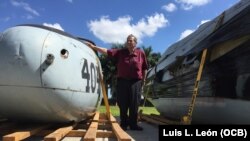 El veterano de Bahía de Cochinos, el cubano Félix Rodríguez Mendigutía, posa ante una parte del avión donado por el gobierno de Guatemala a la Brigada 2506. (L.L.León).