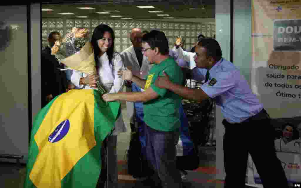  La médica cubana Yaisel Perea (i) es recibida por manifestantes que apoyan la llegada de doctores de Cuba al país, durante una recepción para un grupo de 200 profesionales hoy, sábado 24 de agosto de 2013, al aeropuerto de Brasilia. La presidenta brasile