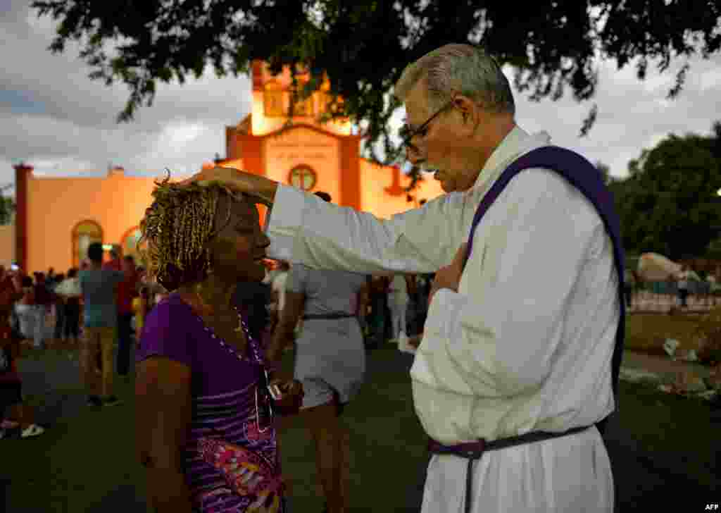 Un sacerdote bendice a un peregrino durante la procesi&#243;n a El Rinc&#243;n en adoraci&#243;n a San L&#225;zaro. Yamil Lage/AFP