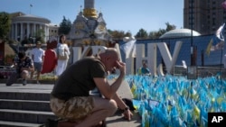 Un veterano rinde homenaje en un monumento improvisado a los soldados ucranianos caídos en la guerra ruso-ucraniana durante el Día de la Independencia de Ucrania, el sábado 24 de agosto de 2024. (Foto AP/Efrem Lukatsky)