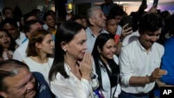 La aspirante presidencial de la oposición María Corina Machado, centro, escucha los resultados de la votación que nombró a su ganadora de las elecciones primarias de la oposición, en su sede de campaña en Caracas, Venezuela, 23 de octubre de 2023. AP/Ariana Cubillos