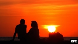 Una pareja conversa en el malecón de La Habana.