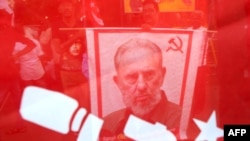 La imagen del dictador Fidel Castro entre banderas y símbolos del comunismo.