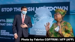 Ngozi Okonjo-Iweala, directora general de la Organización Mundial de Comercio (dcha.), junto a una escultura de hielo hecha para concienciar sobre la pesca excesiva, el 1 de marzo, su primer día en el cargo, en Ginebra.